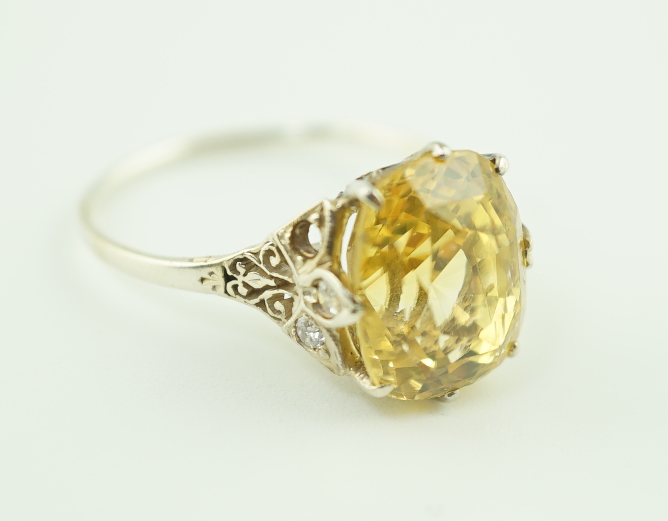 A mid 20th century platinum? and single stone fancy cushion cut yellow sapphire set dress ring with six stone diamond set pierced mount